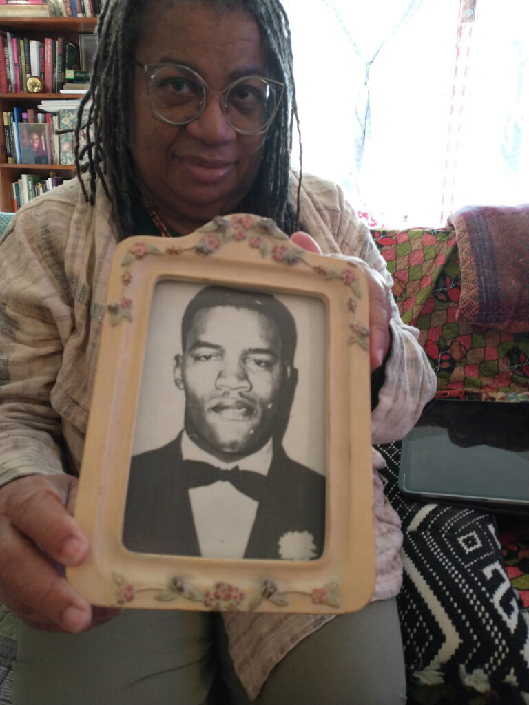 Ms. Judy Juanita holds up a photo of her father